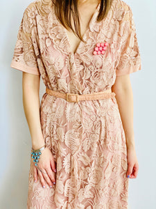 model wearing 1940s vintage pink lace dress with matching belt and pink brooch 