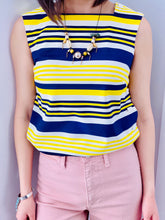 Load image into Gallery viewer, 1960s yellow and blue striped top with side square buttons and pink pants on model 

