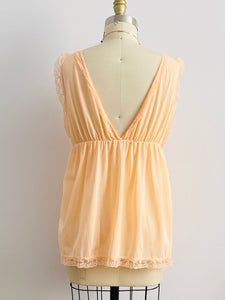 back view of a 1960s peach color lace ribbon lingerie top on mannequin