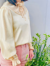 Load image into Gallery viewer, model wearing a vintage beige color satin blouse with lace ruffled collar and balloon sleeves
