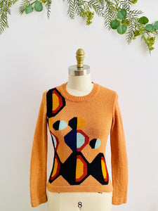 mannequin display a vintage orange color sweater with art deco pattern