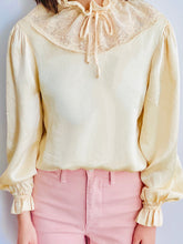 Load image into Gallery viewer, model wearing a vintage beige color satin blouse with lace ruffled collar and balloon sleeves Pink pants 
