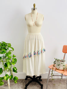 mannequin displays a vintage 1970s white embroidered cotton skirt 