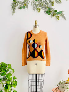 mannequin display a vintage orange color sweater with art deco pattern