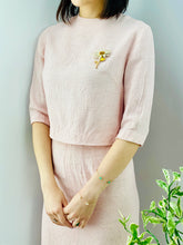 Load image into Gallery viewer, model wearing a 1940s pink linen two piece set with daisy brooch
