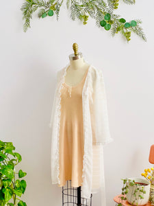 1920s peach color wool slip dress an white sheer robe on mannequin