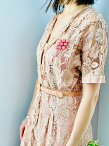 side view of model wearing 1940s pink lace dress with belt and pink brooch