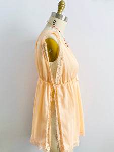 side view of a 1960s peach color lace ribbon lingerie top on mannequin