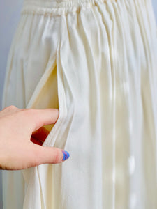 pocket of a side view of a mannequin displays a vintage 1970s white cotton embroidered skirt