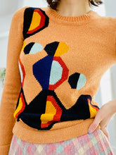 Load image into Gallery viewer, model wearing a vintage orange color sweater with art deco pattern
