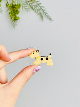 Load image into Gallery viewer, hand holding a vintage 1920s celluloid scottie terrier dog brooch 
